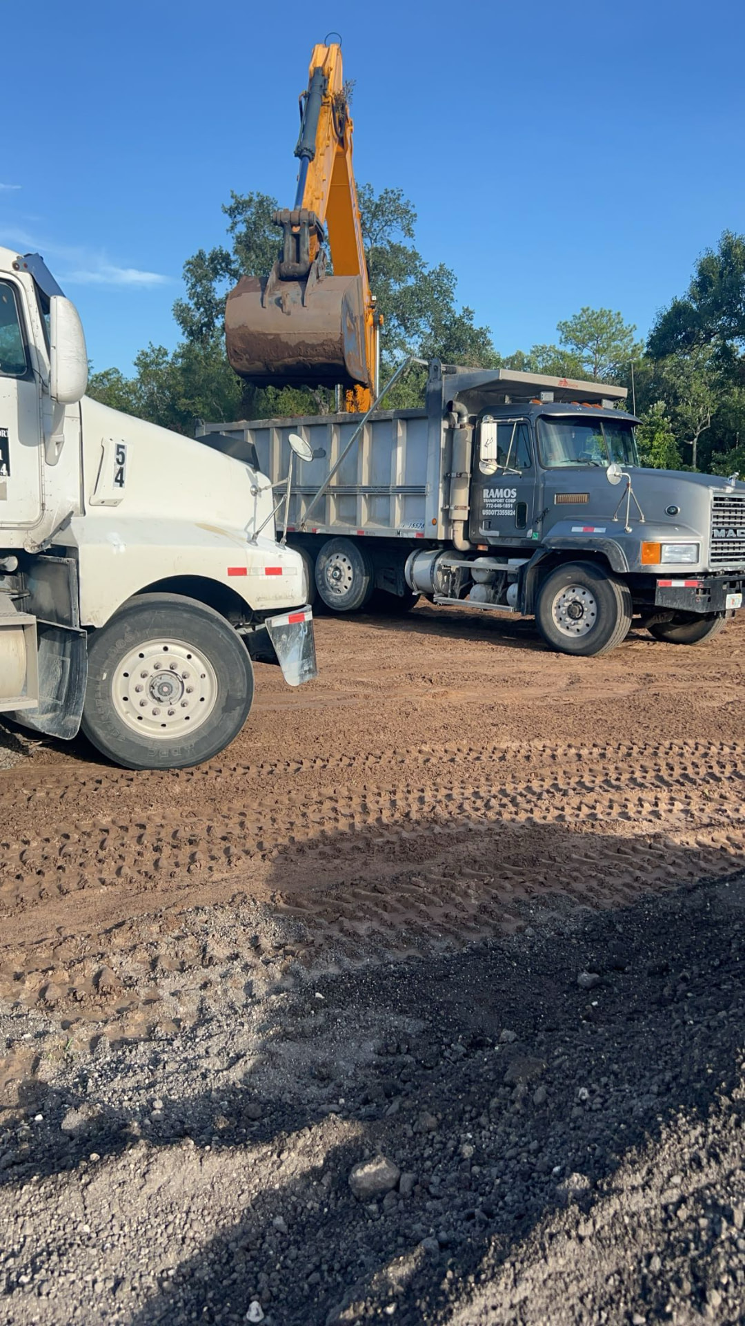 Dump truck unloading drainage rock at a job site